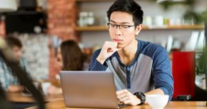 Pensive college student using laptop