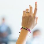 student raising hand on class