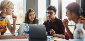 Diverse group of four students working on a project