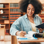Young woman smiling as she studies in a library