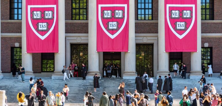 Widener Memorial Library at Harvard University, with Veritas banners hanging and throngs of students on the steps