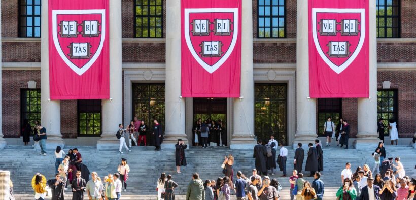 Widener Memorial Library at Harvard University, with Veritas banners hanging and throngs of students on the steps
