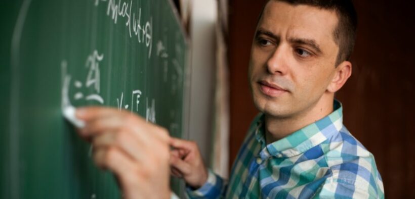 young professor at chalkboard